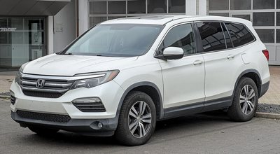 white Honda SUV parked in front of a building with large windows