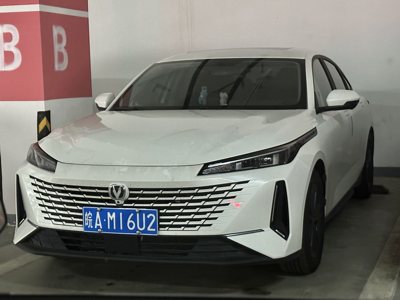 white modern sedan car parked in an indoor parking space with distinctive front grille and blue license plate
