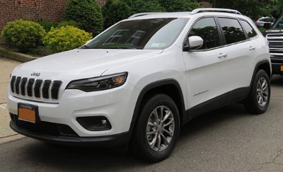 white Jeep Cherokee SUV parked on a residential street showing front and side view