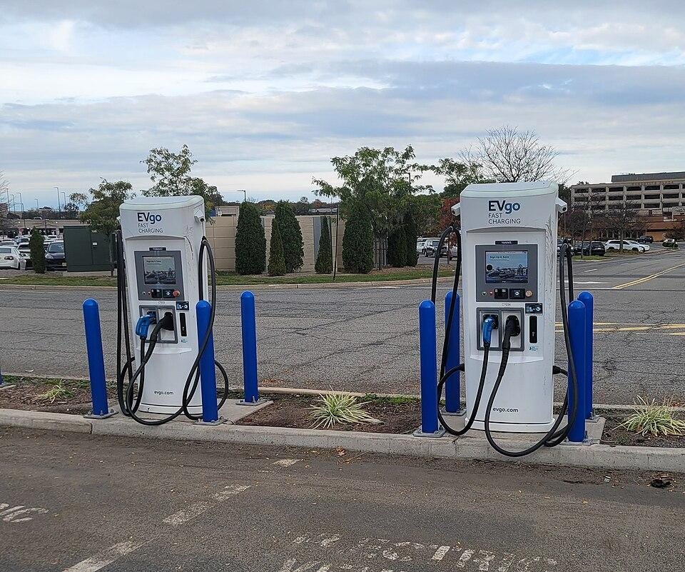 two EVgo fast charging stations for electric vehicles in an outdoor parking lot with blue protective bollards around them