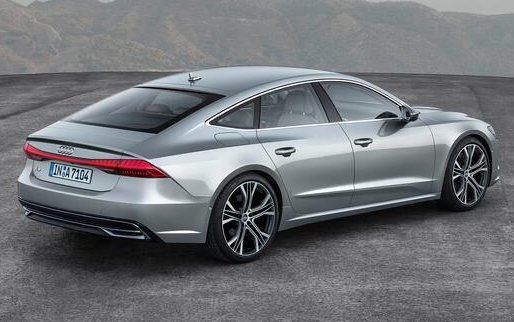 silver Audi sedan car viewed from the rear side with mountain background on a paved surface