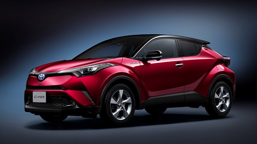 side front view of a red Toyota C-HR compact crossover SUV against a dark gradient background