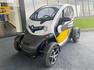 compact Renault electric microcar with yellow accents parked outside a building on a paved surface