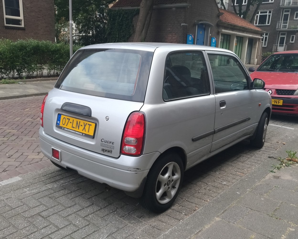Rear and side view of a compact two-door hatchback with sport badge and alloy wheels.