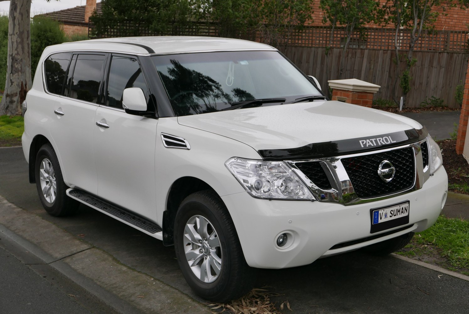 White SUV with bold grille and distinct headlights, side view