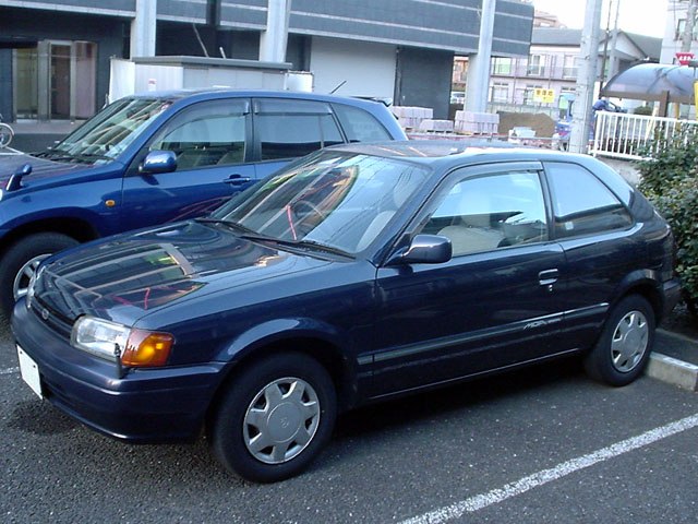 Compact 3-door hatchback side view with typical mid-90s styling