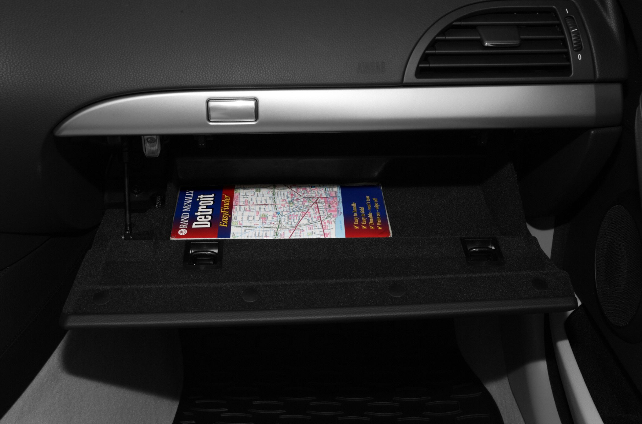 Open car glove box with a Detroit map inside