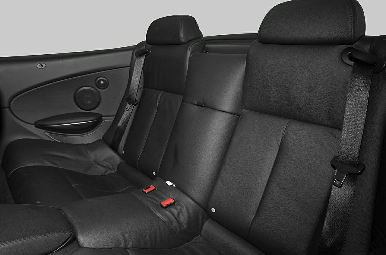 Rear black leather seats with seat belts in a convertible