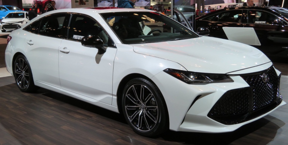 White sedan with black mesh grille and multi-spoke alloy wheels