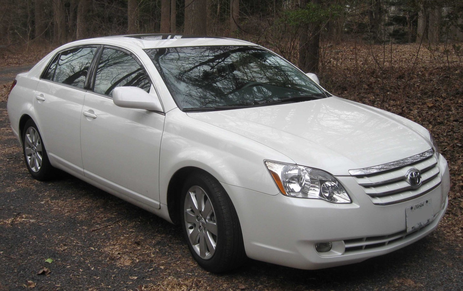 Sleek front and side view of a white sedan with distinctive headlights and grille