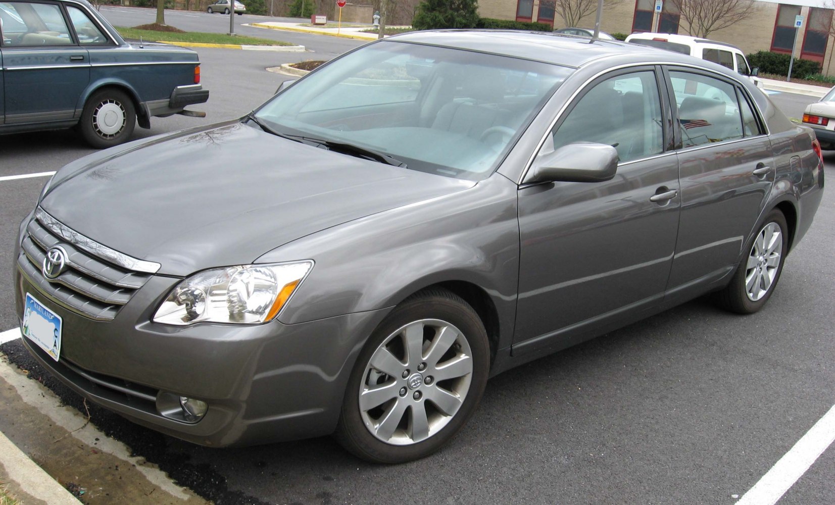 Mid-2000s sedan front side view with alloy wheels and chrome grille