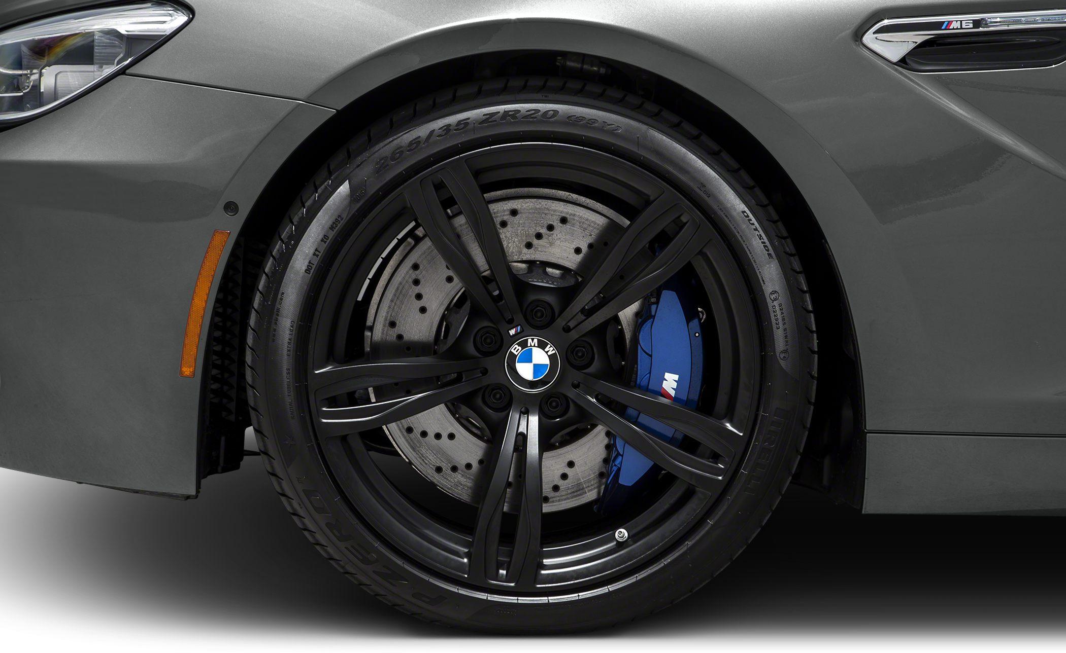 Black alloy wheel with perforated disc and blue brake caliper on a sport vehicle.
