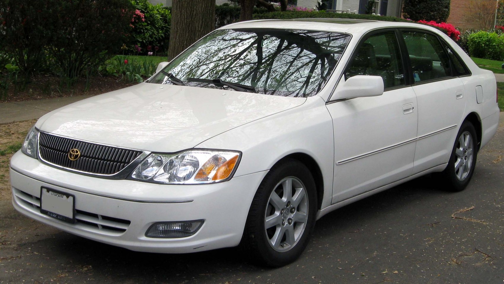 White mid-size sedan with multi-element headlights and chrome grille