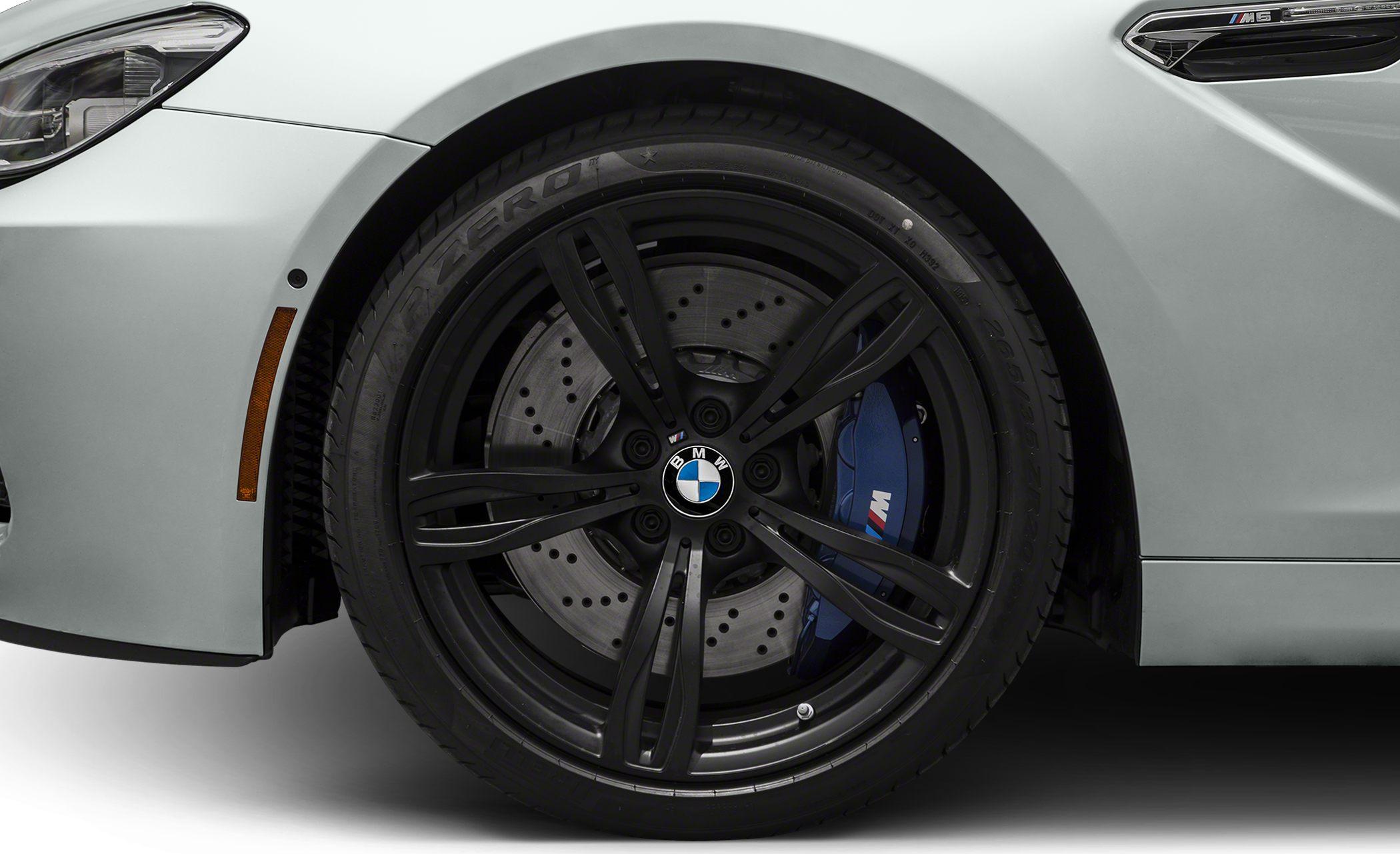 Black alloy wheel with M logo blue brake caliper and perforated disc brake