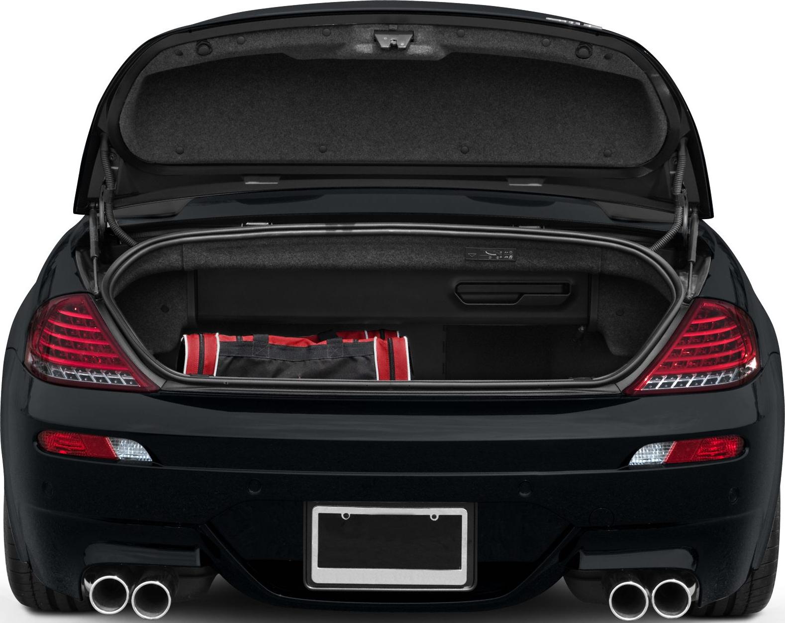 Open trunk with visible interior cargo and dual exhaust pipes.
