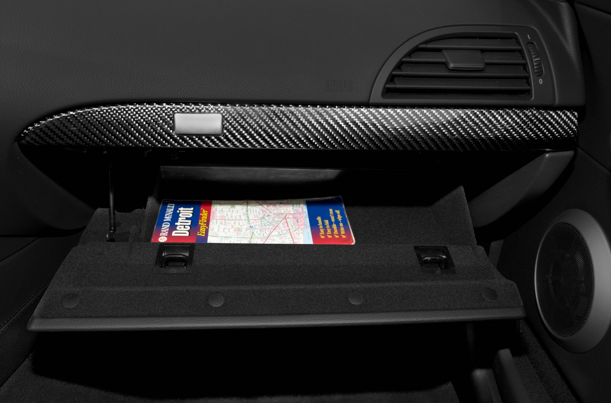 Open glove box with carbon fiber trim and map inside