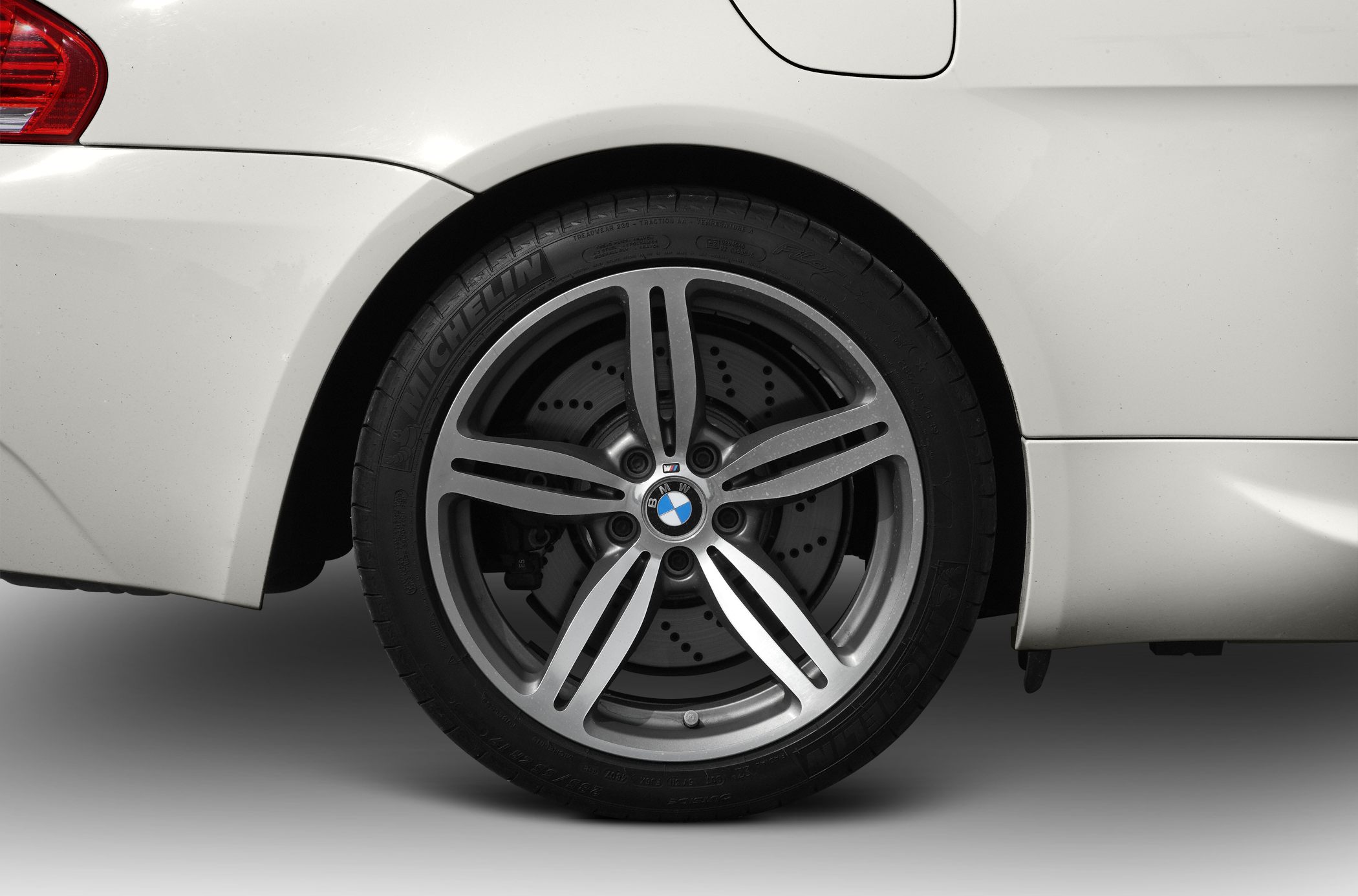 Close-up of rear alloy wheel and drilled brake disc