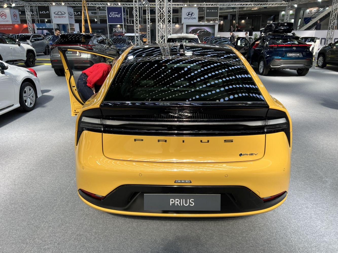 Rear view of a car with sleek continuous tail light and yellow paint