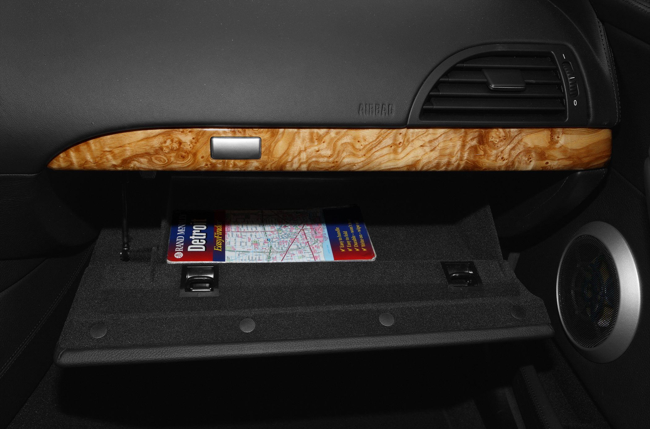 Glovebox interior with wood trim and a map