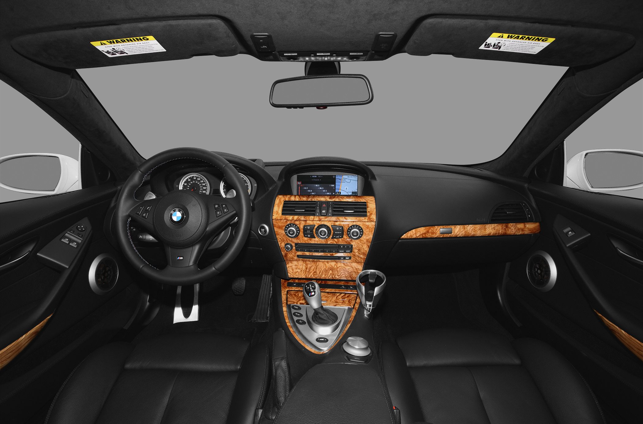 Luxury car interior with wood trim, sport steering wheel, and infotainment system