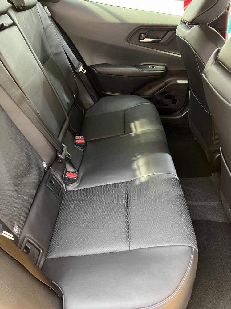 Rear seat with black leather upholstery and seatbelts