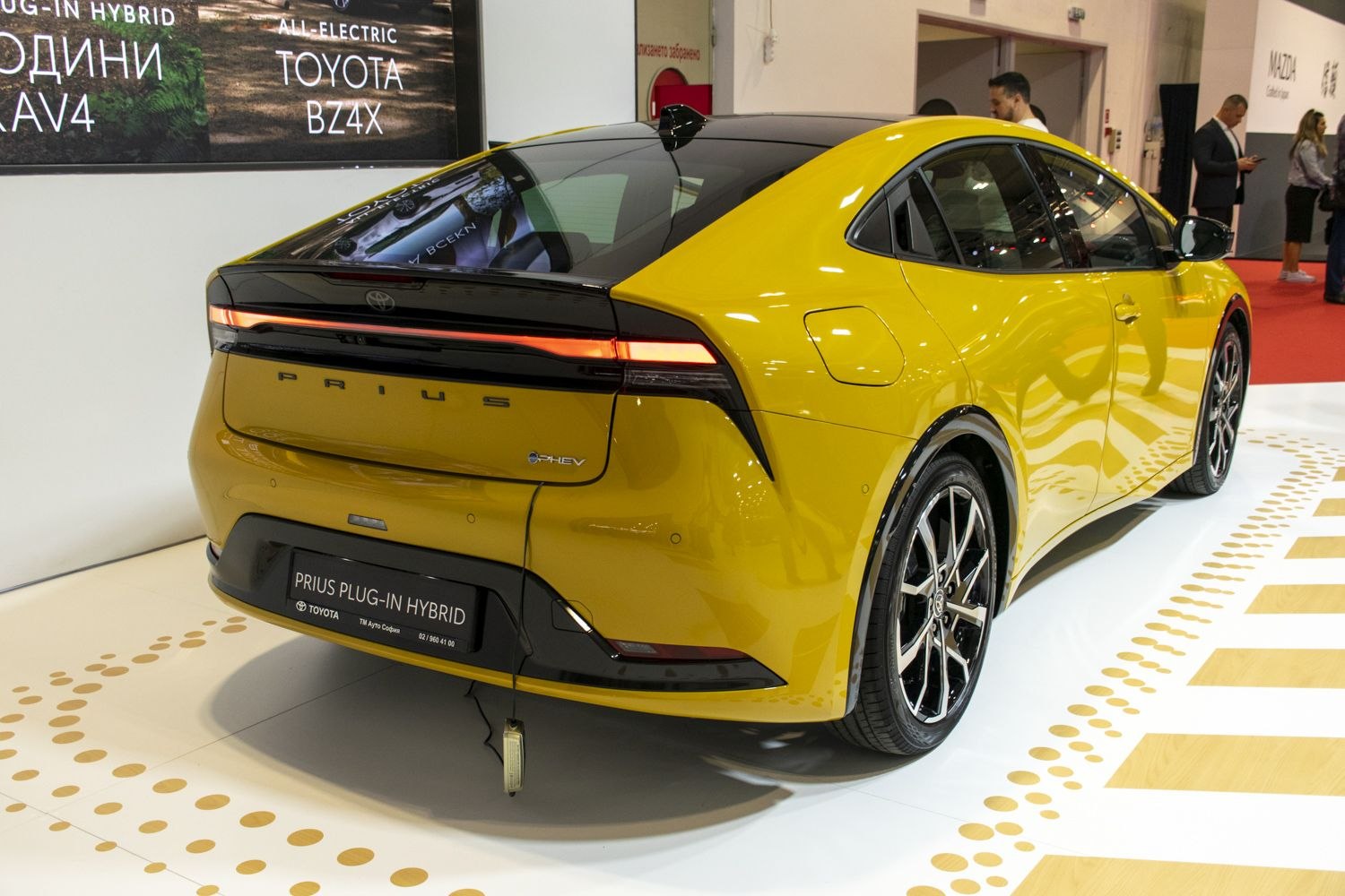 Rear view of a yellow vehicle with sleek taillights and plug-in hybrid badging