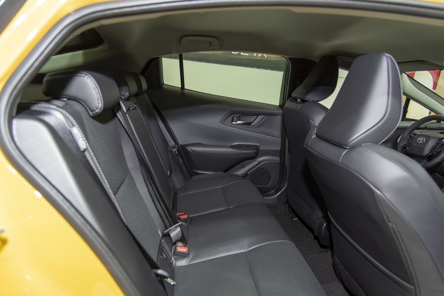 Black rear passenger seat interior with door panel and seat belts