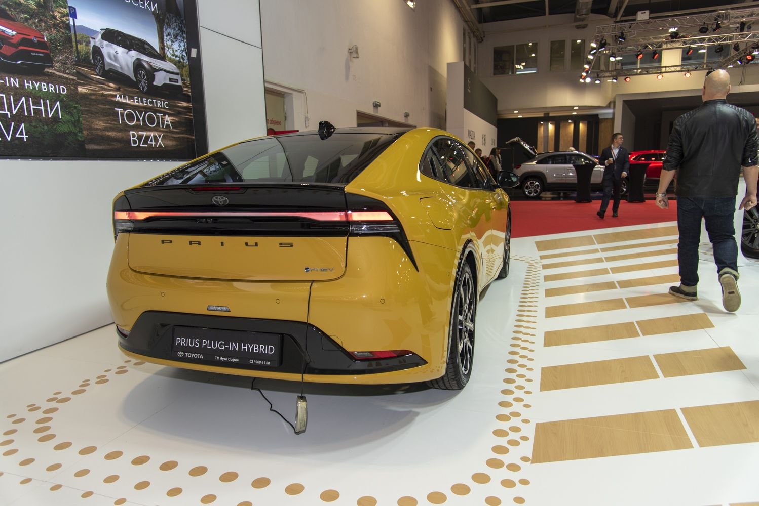 Rear view of a yellow plug-in hybrid hatchback with sleek tail light bar