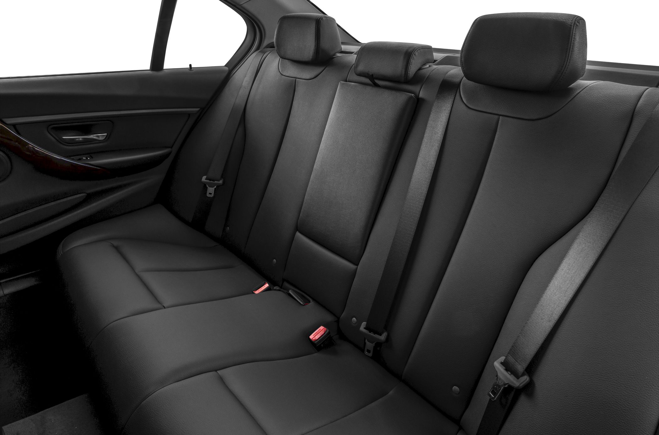 Black leather rear seats with headrests and seat belts in a sedan.