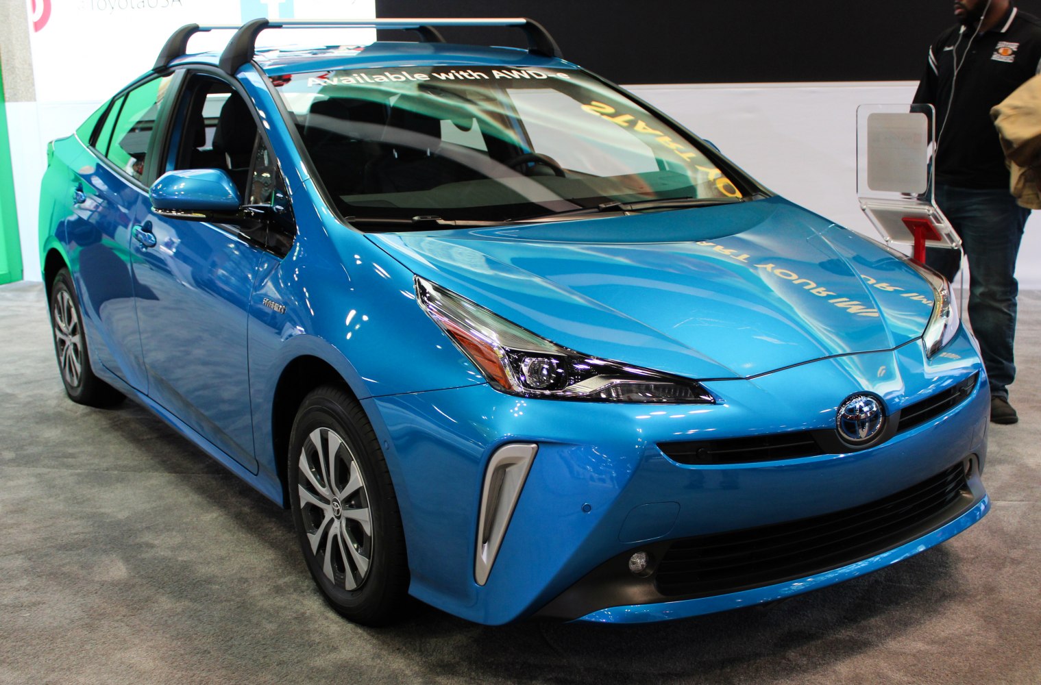 Front angle view of blue hybrid sedan with roof rack and sleek headlights