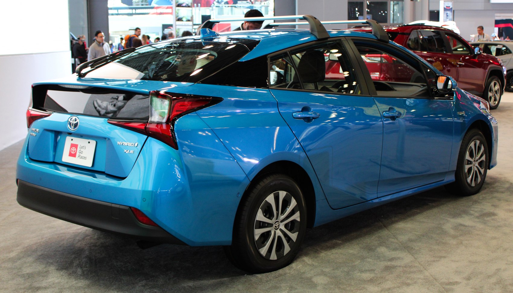 Rear and side view of a hybrid hatchback with distinct aerodynamic design and hybrid badge.