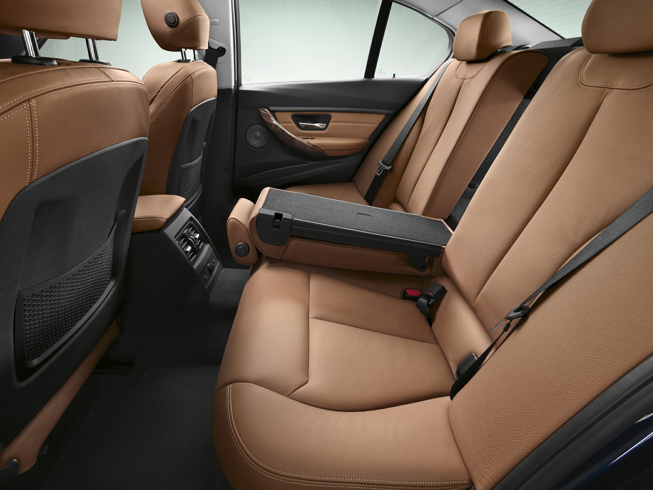 Rear seat interior with tan leather upholstery and center armrest