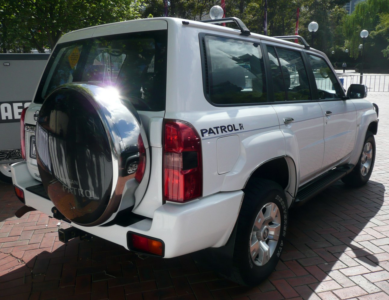 Rear side view of SUV with spare tire cover and roof rails