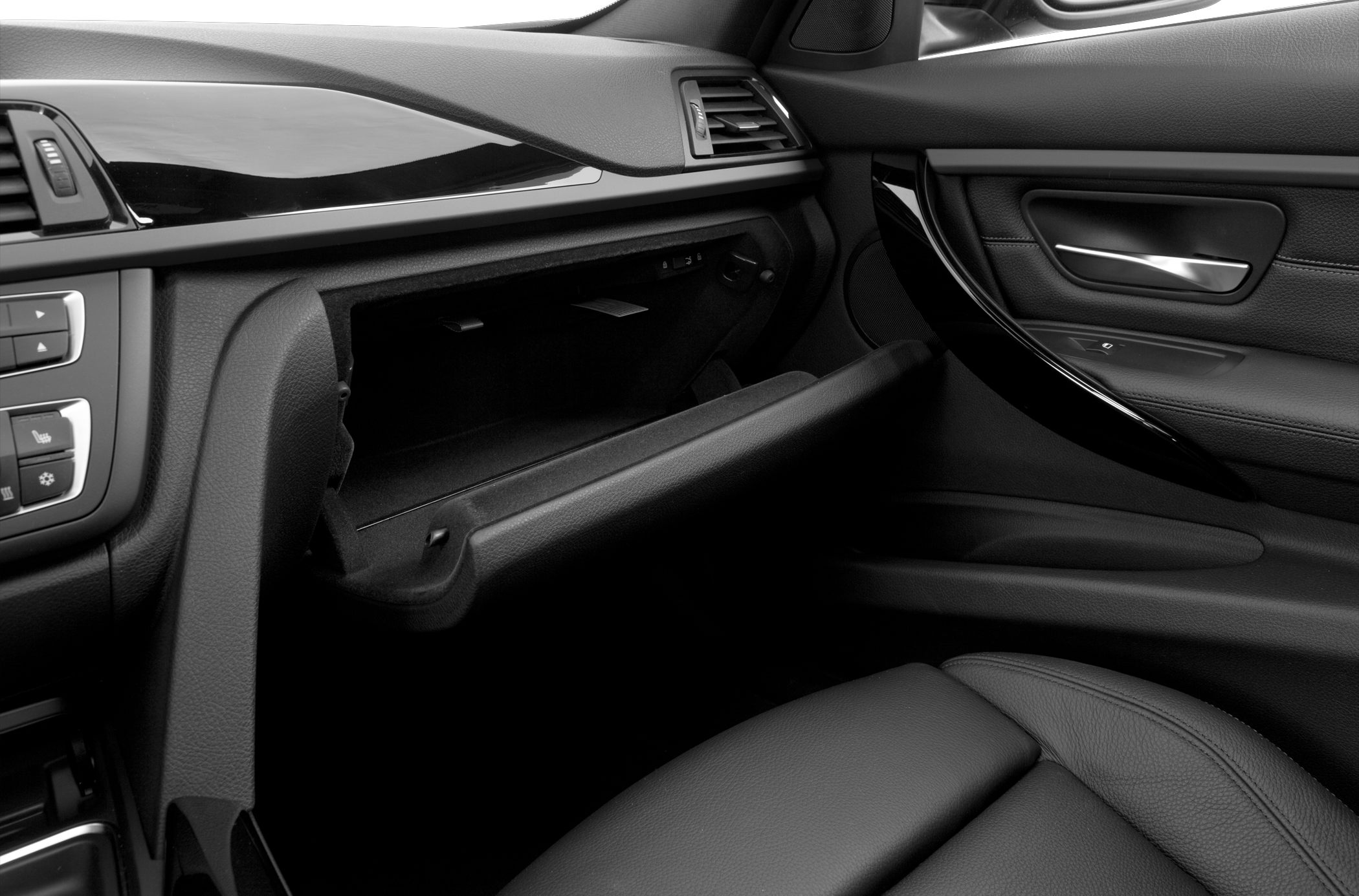 Open glove compartment in sleek black car interior