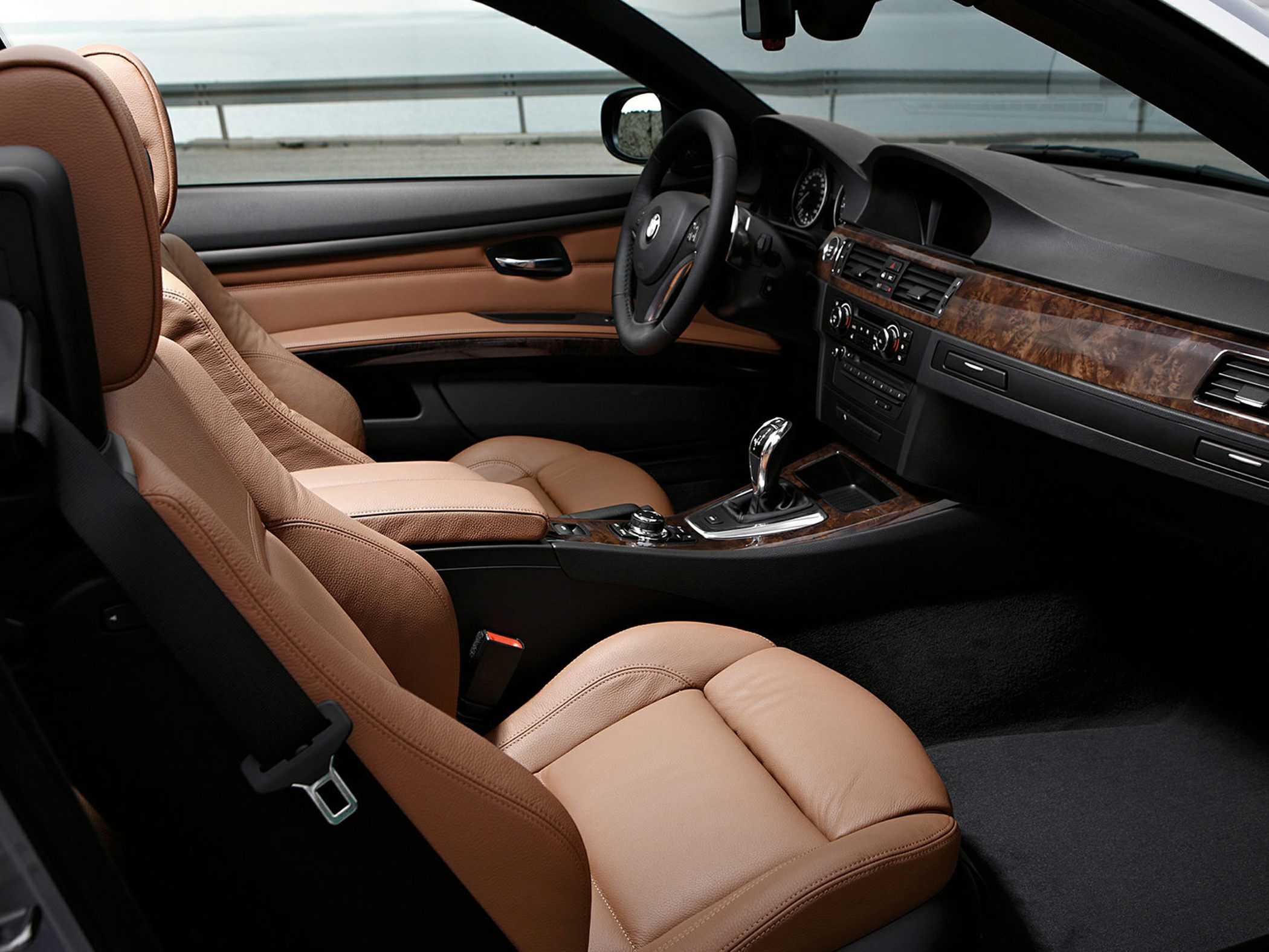 Brown leather seats and wood trim interior with gear shifter