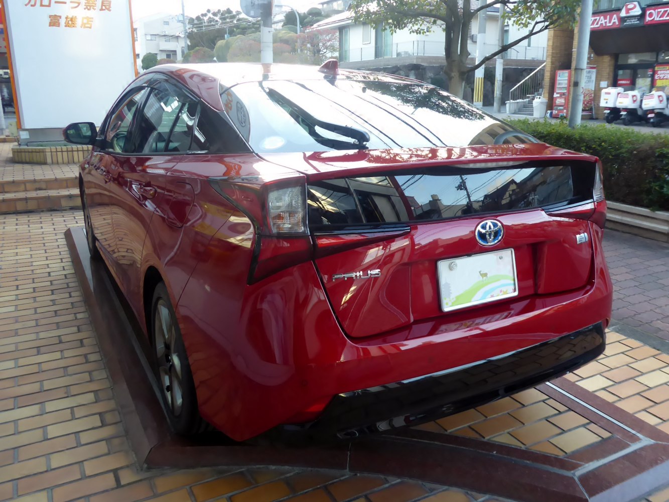 Red hatchback rear with distinctive taillights and rear window design.