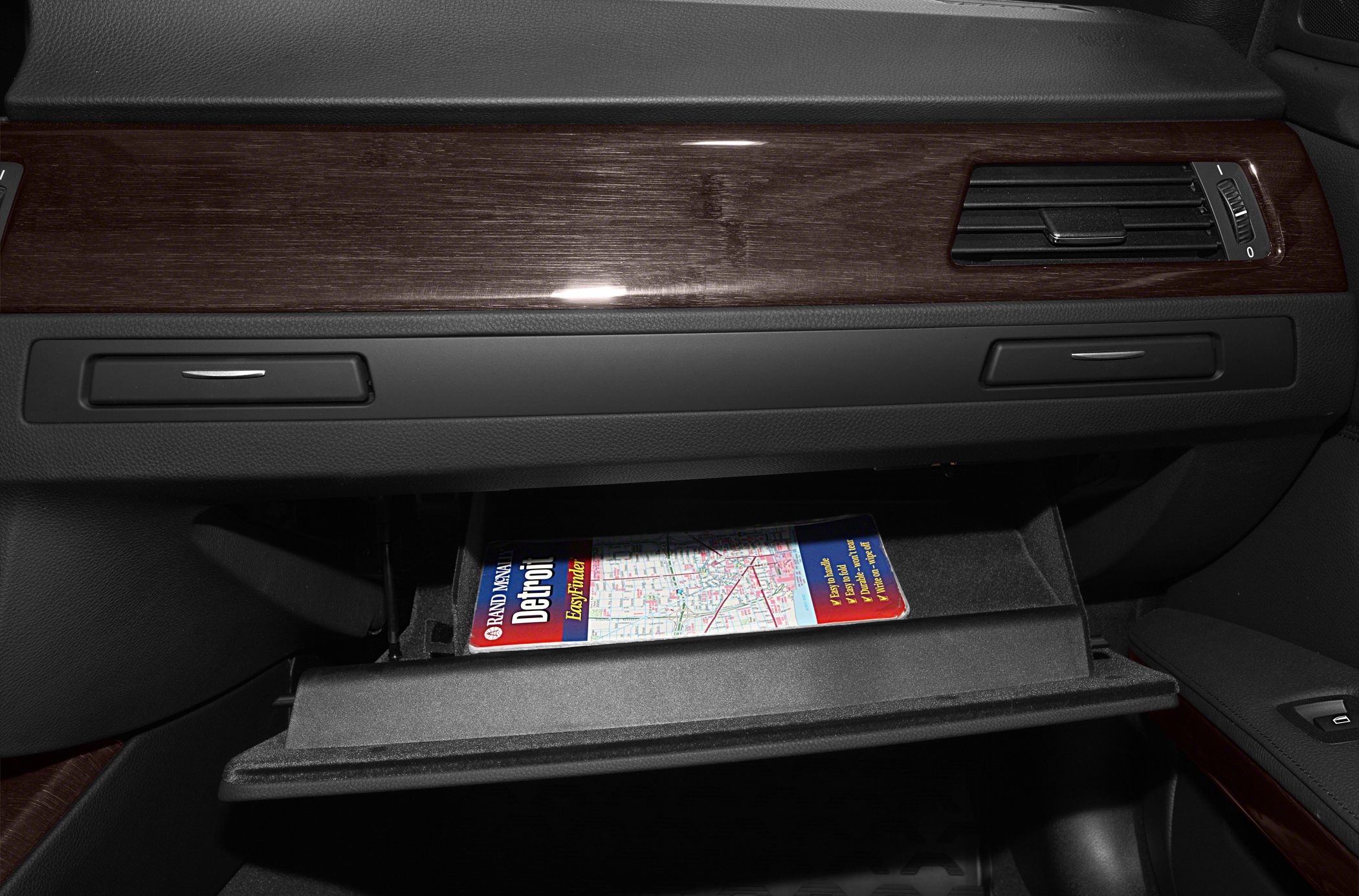Wood dashboard trim and open glovebox in car interior