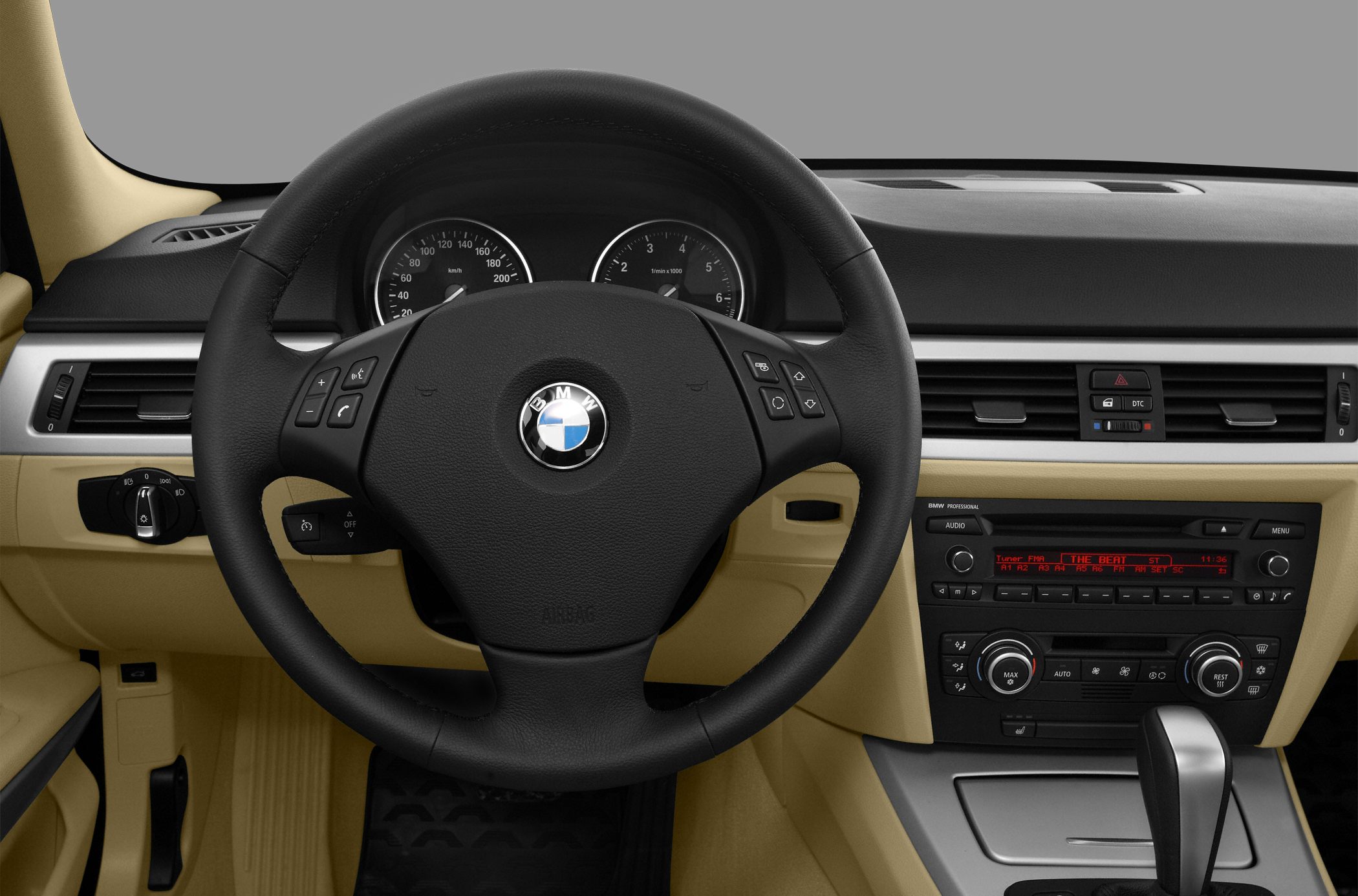Black steering wheel and dashboard control panel with beige interior trim.
