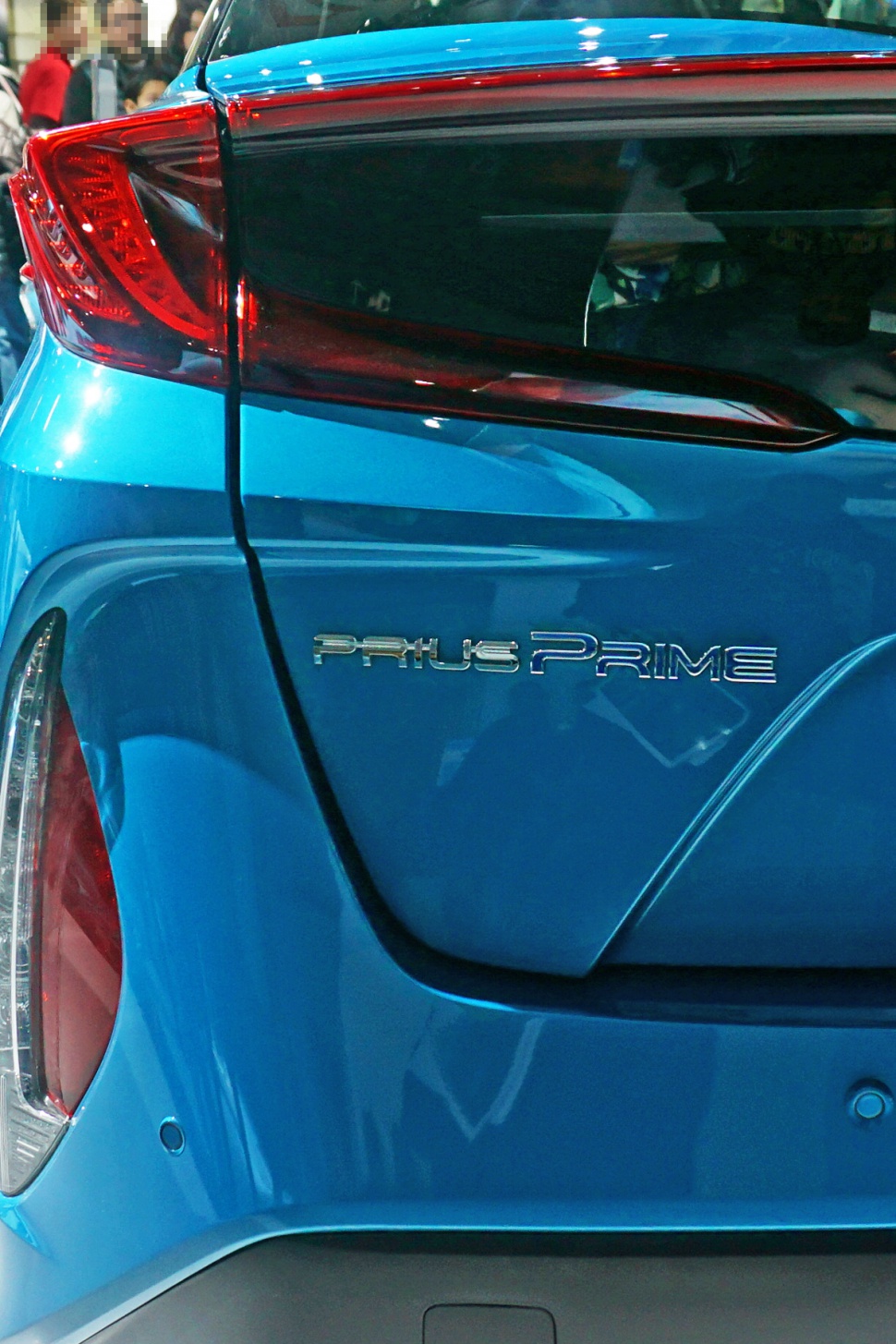 Close-up of rear light and 'Prius Prime' badge on blue vehicle.
