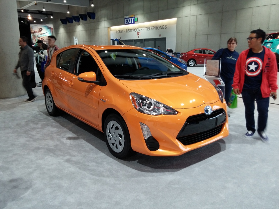 Orange compact hatchback with aerodynamic front and distinctive headlights