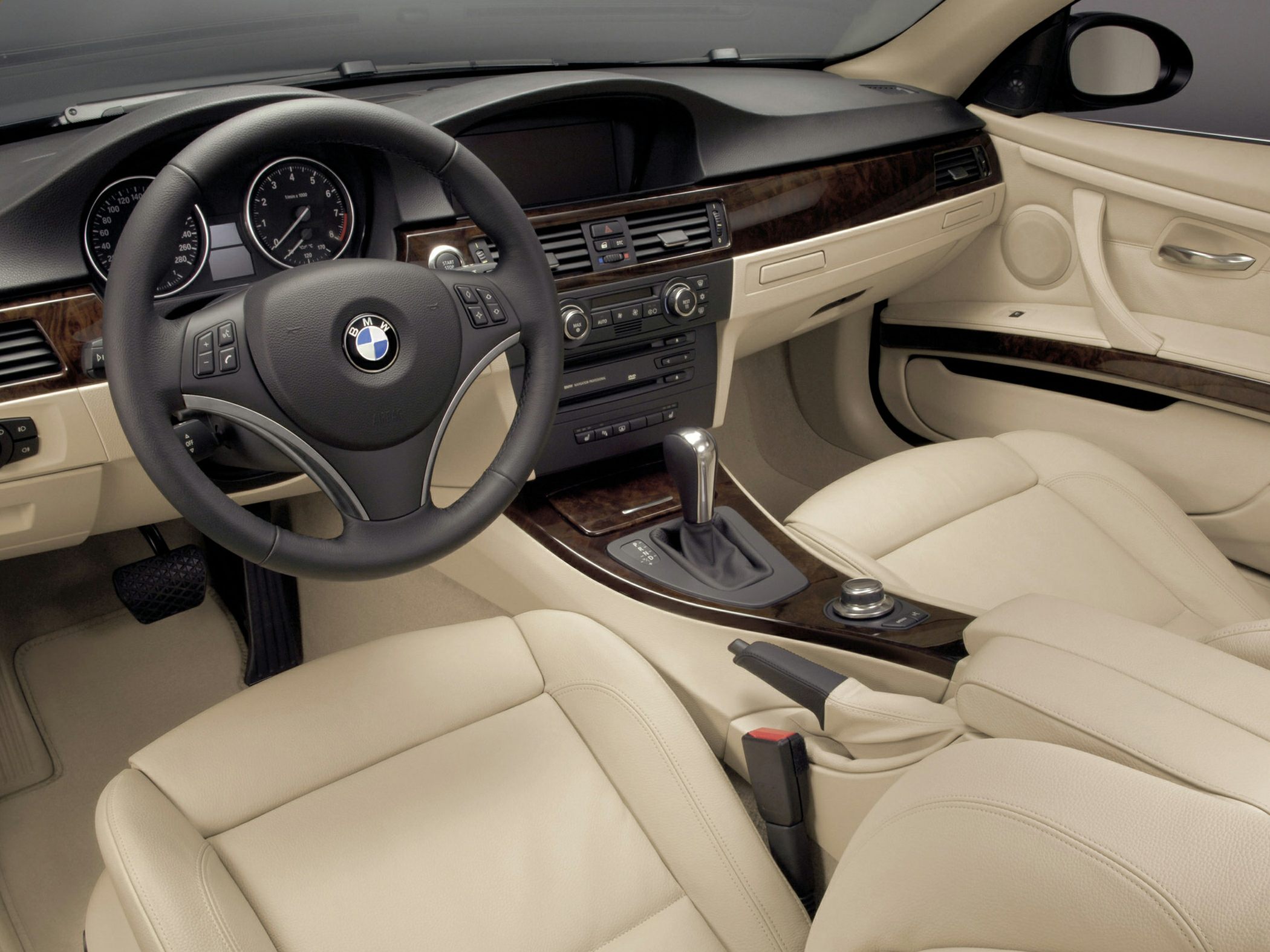 Leather steering wheel and wood grain dashboard in beige leather interior