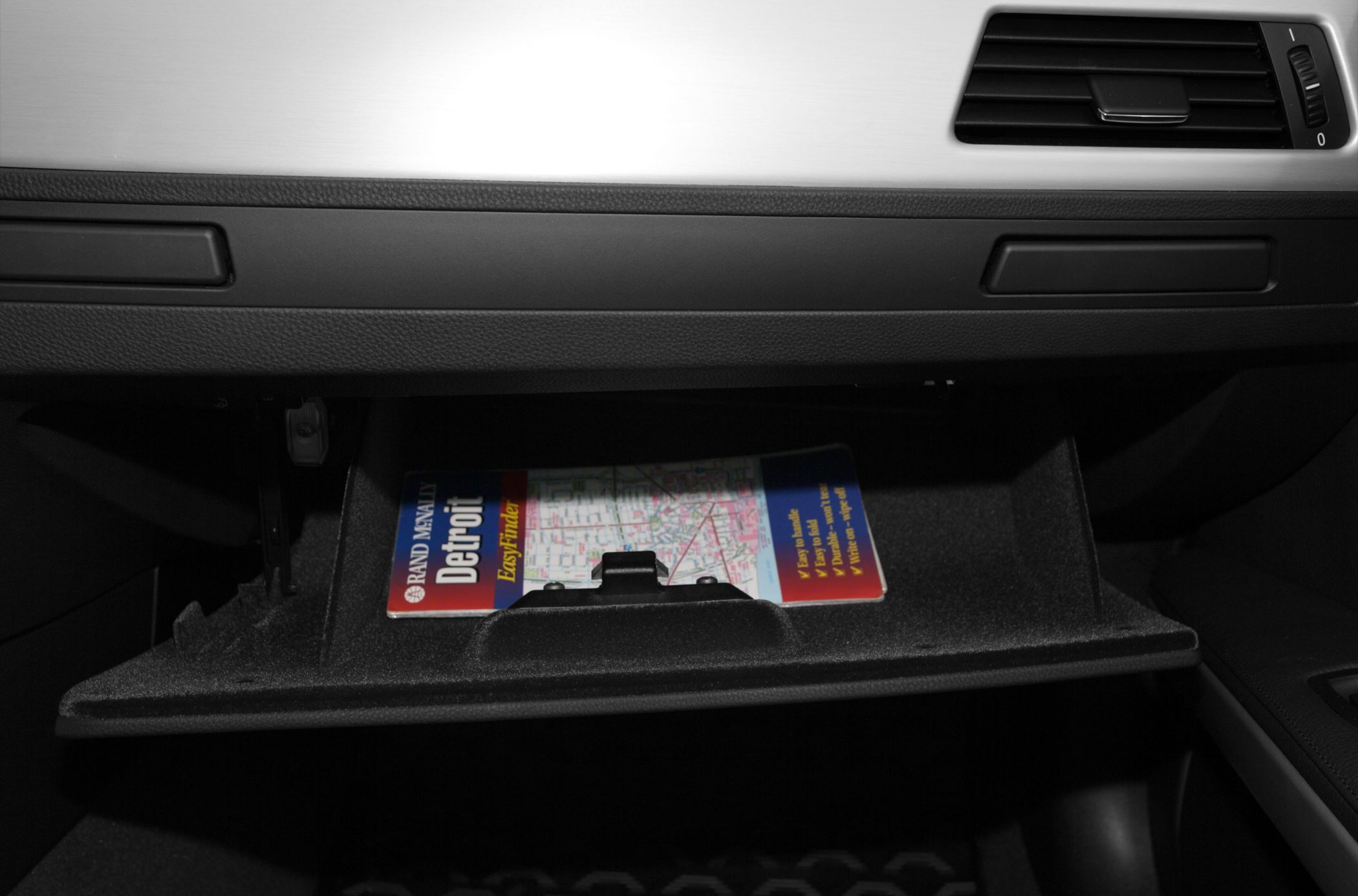 Open glove compartment with a Detroit map inside