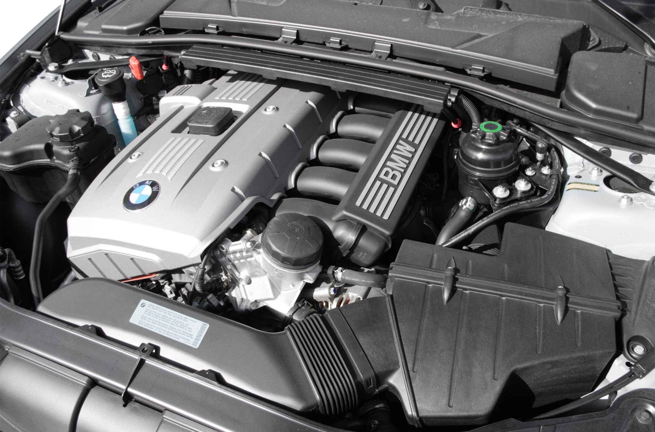 Inline engine bay with BMW-branded engine cover and visible components