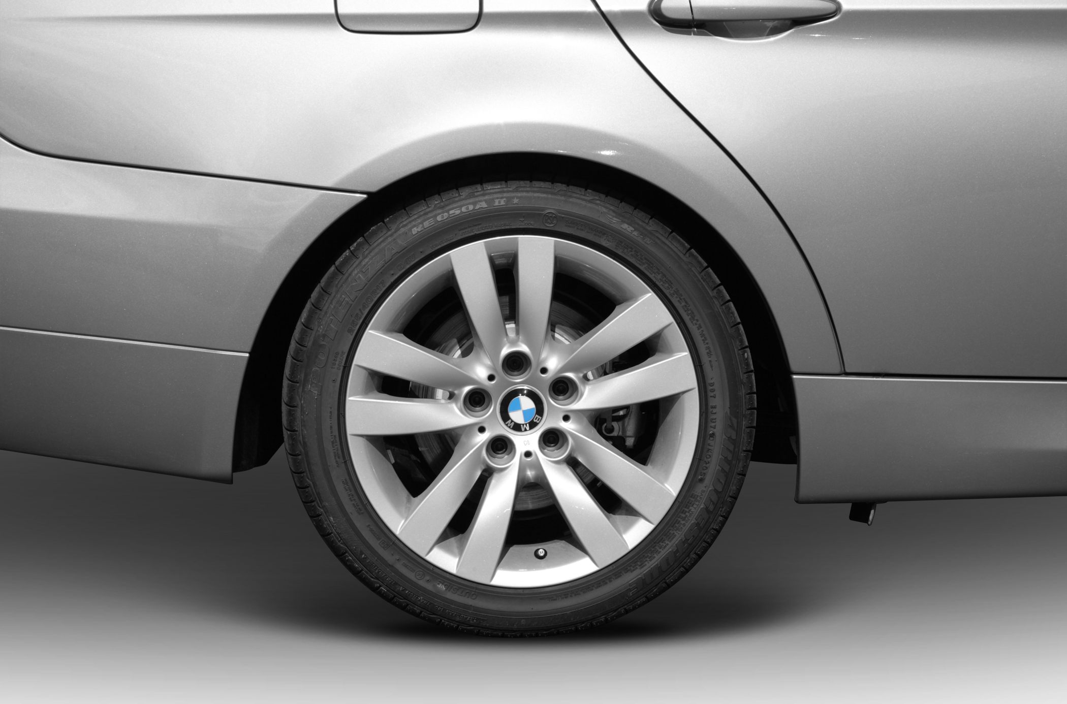 Silver alloy multi-spoke wheel with BMW roundel.