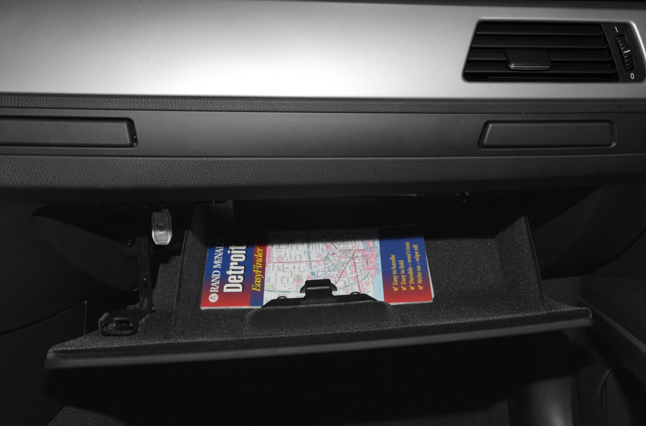 Open glovebox with map inside in car interior