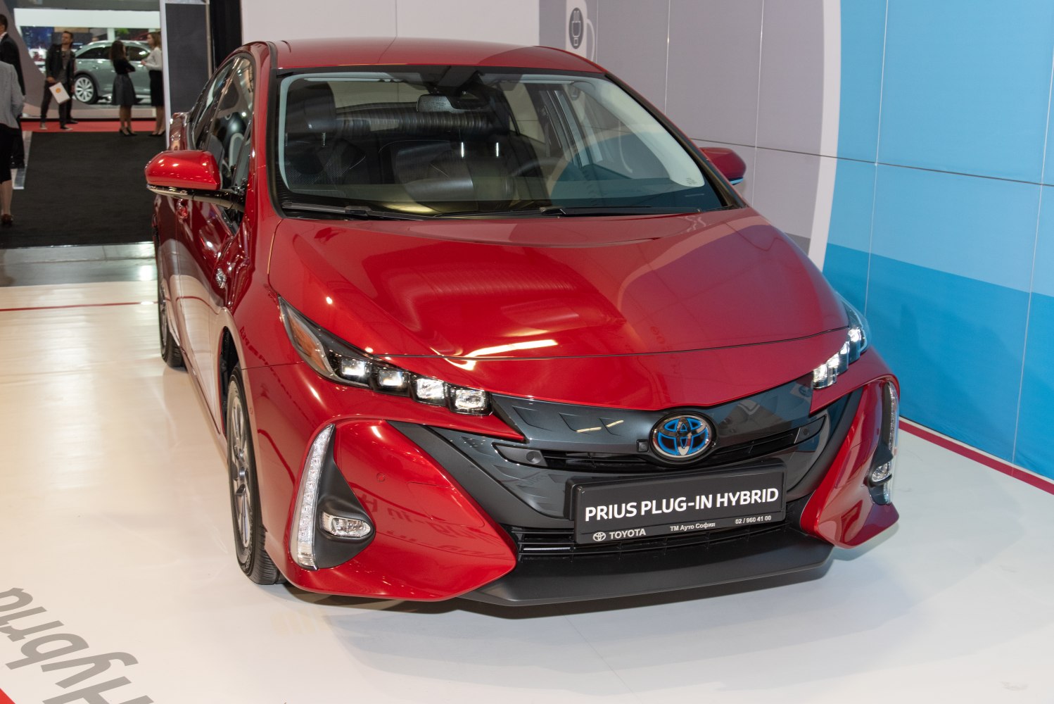 Red hybrid car front with LED headlights and aerodynamic design