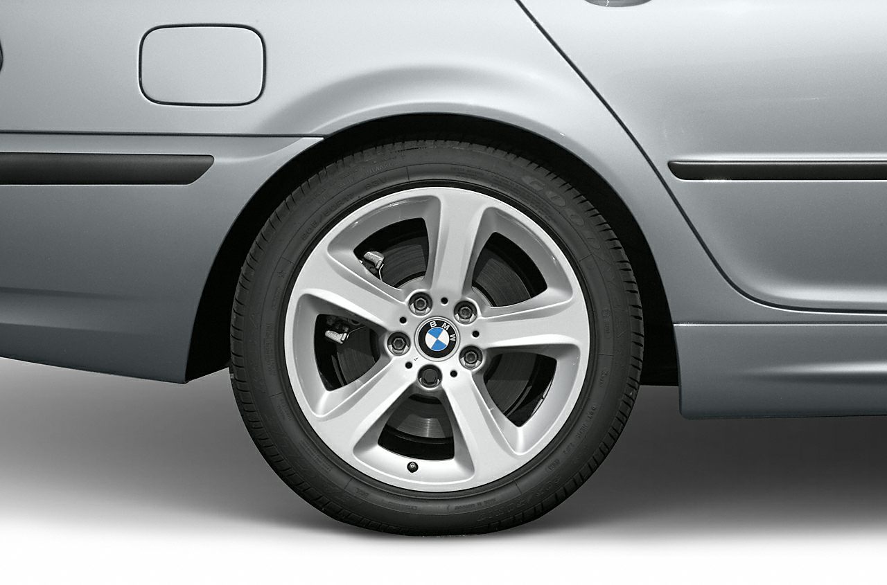 Rear alloy wheel rim and fuel cap area of a sedan.