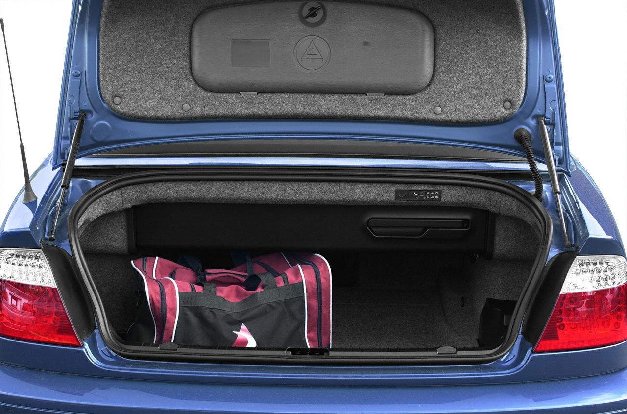 Open rear trunk with duffel bag in a blue convertible car