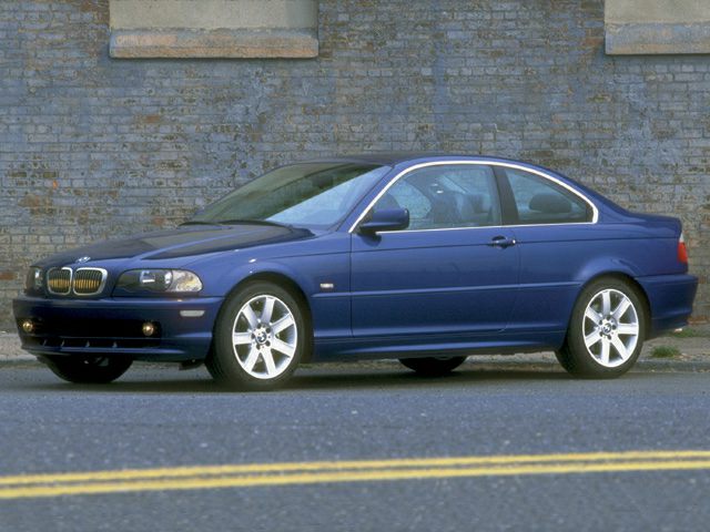 Sporty two-door coupe with alloy wheels parked by brick wall