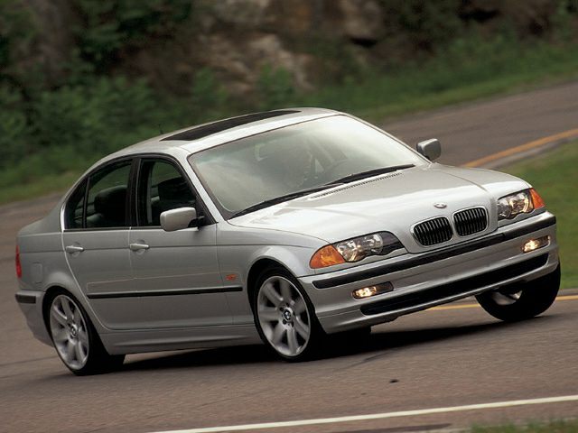 Front side view of BMW 3 Series E36 sedan in motion with sporty stance.